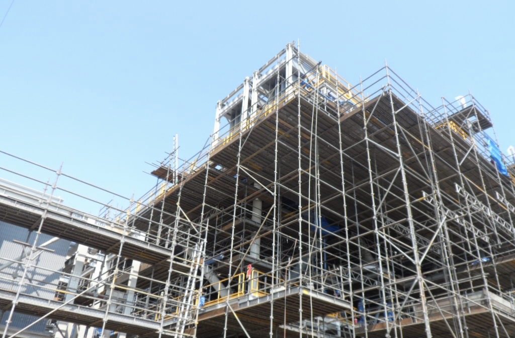 A scaffold tower built against a plant structure